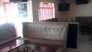 A living room with a sofa, a coffee table, and a television mounted on the wall.