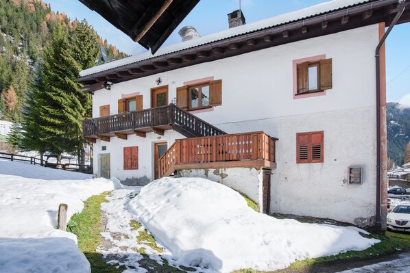 Un bâtiment blanc doté de balcons en bois et d’un escalier.