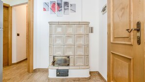 Ein Korridor mit einer weißen Heizung, Holztüren und einem Fliesenboden.