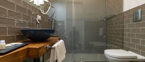 A modern bathroom with a large sink, toilet, and shower area.