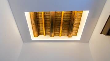 Un plafond avec des poutres apparentes et un luminaire central.