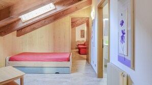 A bedroom with a wooden ceiling, a bed, a table, and a radiator. - Spacious Apartment “Cesa Crepaz” with Mountain View, Wi-Fi & Garden (Canazei)