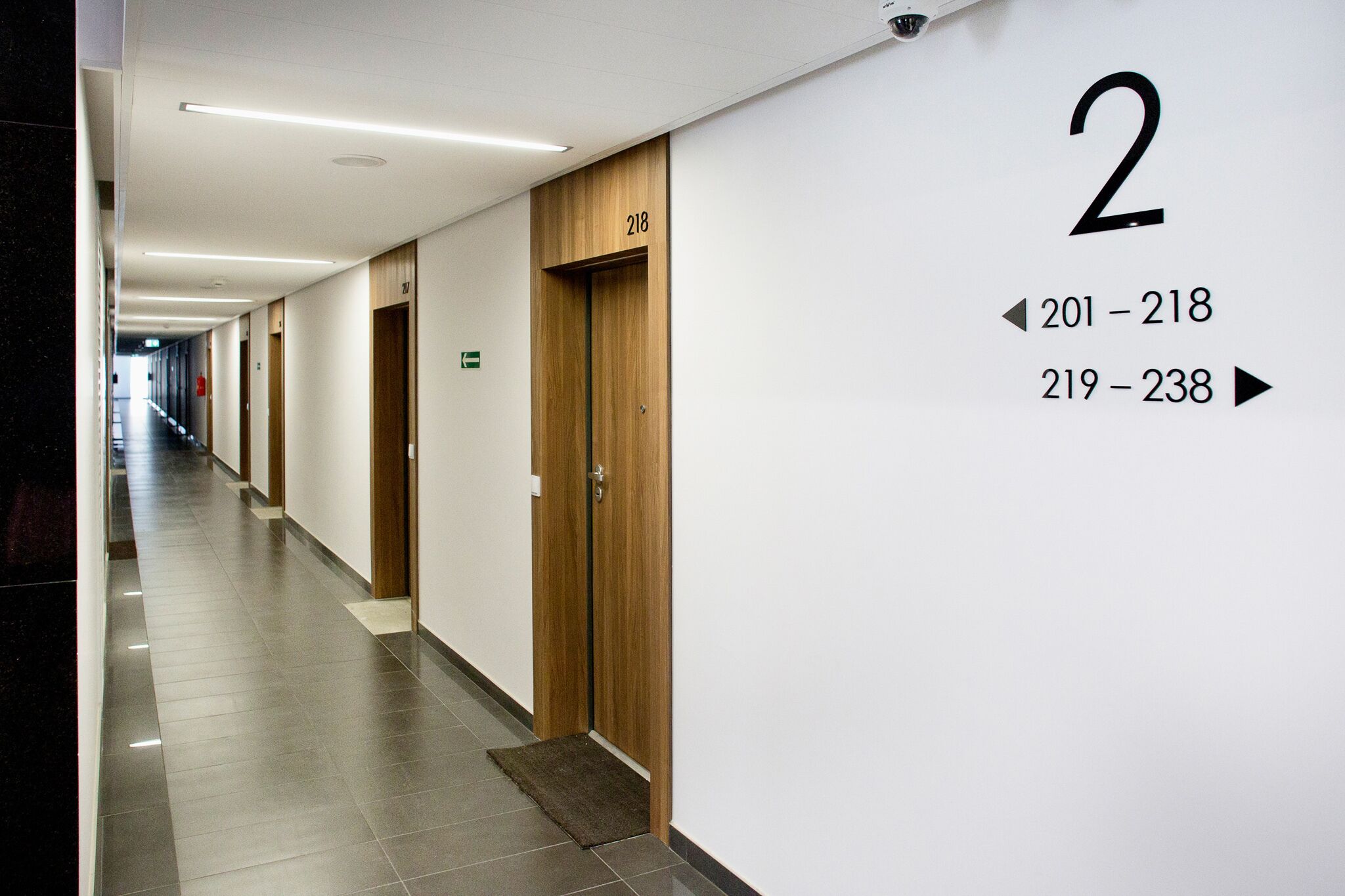 A hotel corridor with doors numbered 201-218 and 219-238, indicating room numbers.