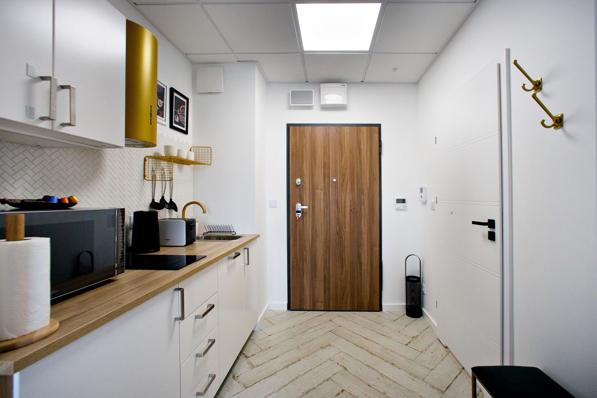 Une cuisine moderne équipée d’un four à micro-ondes, d’un grille-pain et d’un plan de travail en bois.