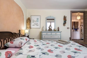 Une chambre à coucher avec un lit, une commode et un miroir.