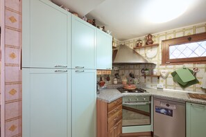 Eine Küche mit Herd, Backofen und Schränken.
