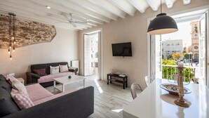 A modern living room with a sofa, coffee table, and a TV mounted on the wall. - Rustic Apartment "Casa Bugambilla" in Very Central Location with Balcony & Wi-Fi (Cadiz)