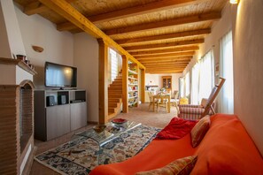 Casa geminada família, vários quartos, ao lado da montanha (La Casa nel Borgo Lake View) | Área de estar | Smart TV 21 polegadas com canais a cabo, DVD player