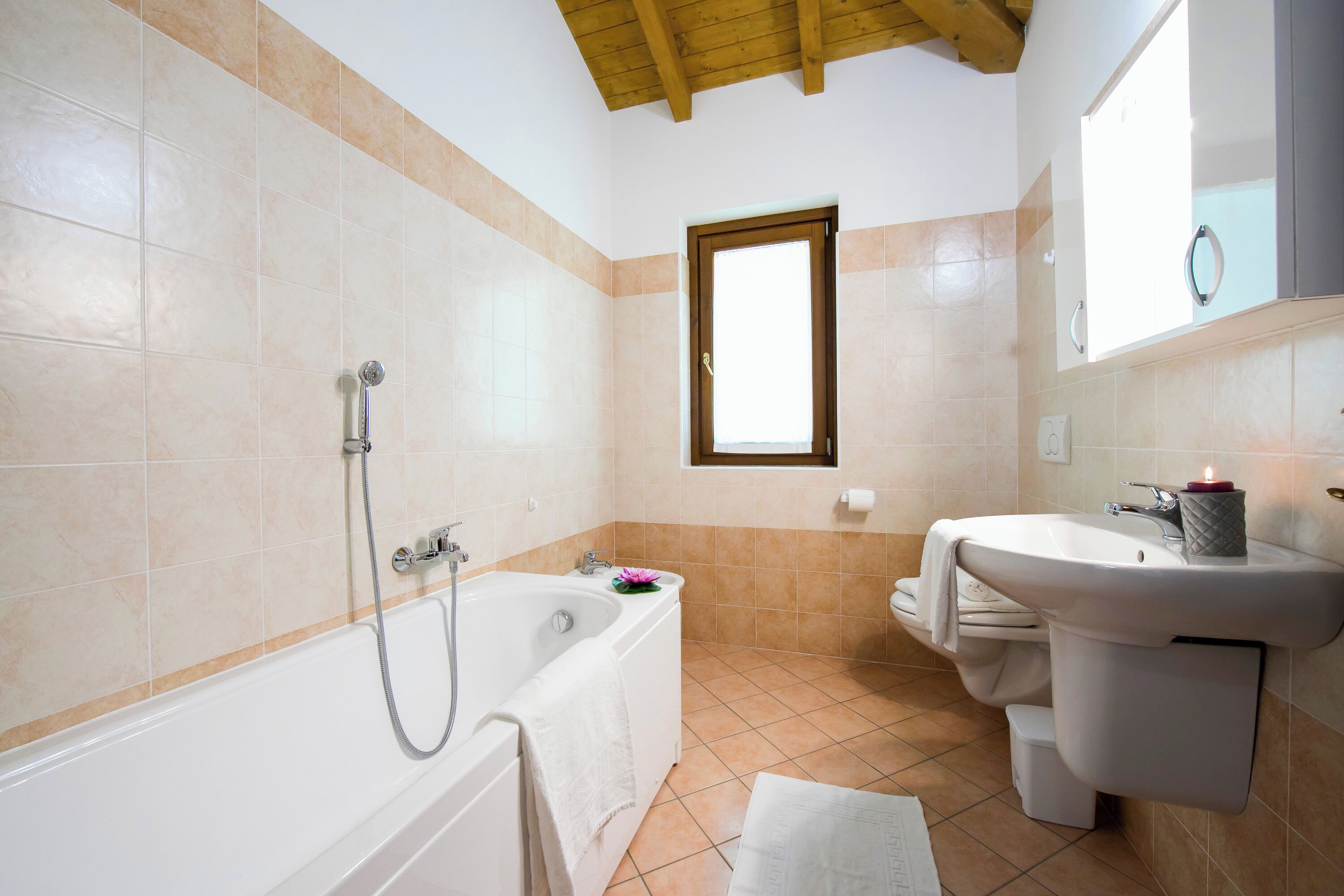 Ein Badezimmer mit Badewanne, Waschbecken und Fenster.