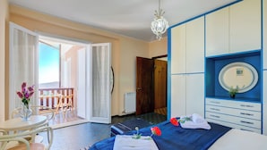 Een hotelkamer met een bed, een bureau en een balkon.
