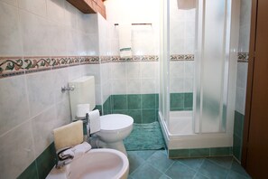 Une salle de bain comprenant des toilettes, un lavabo et un espace douche.