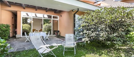 A patio with outdoor furniture, a covered area, and a view of the building's interior.