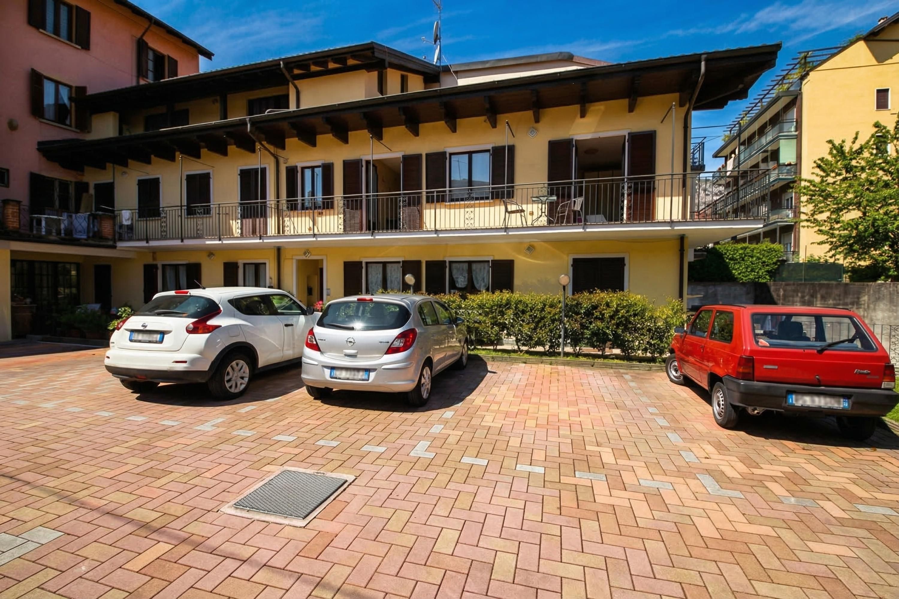 A multi-story residential building with a parking area.
