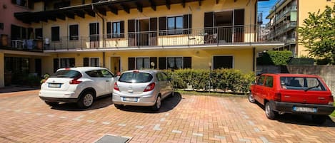 A multi-story residential building with a parking area.