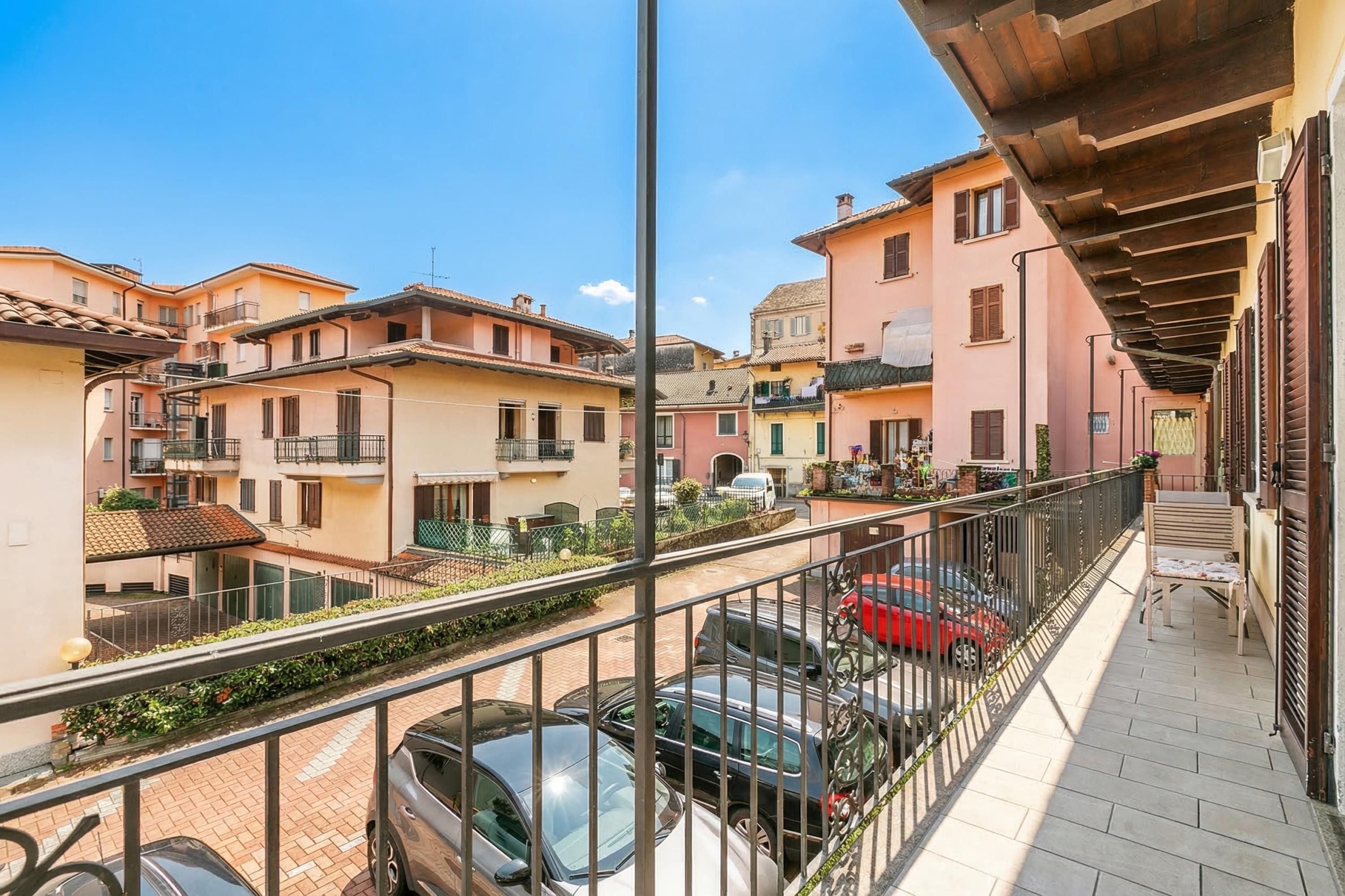 Un quartier résidentiel avec des immeubles à plusieurs étages, un balcon doté d’une rambarde et des voitures garées.