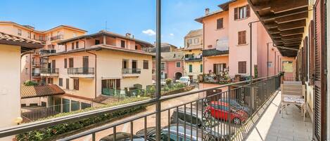 Un quartier résidentiel avec des immeubles à plusieurs étages, un balcon doté d’une rambarde et des voitures garées.