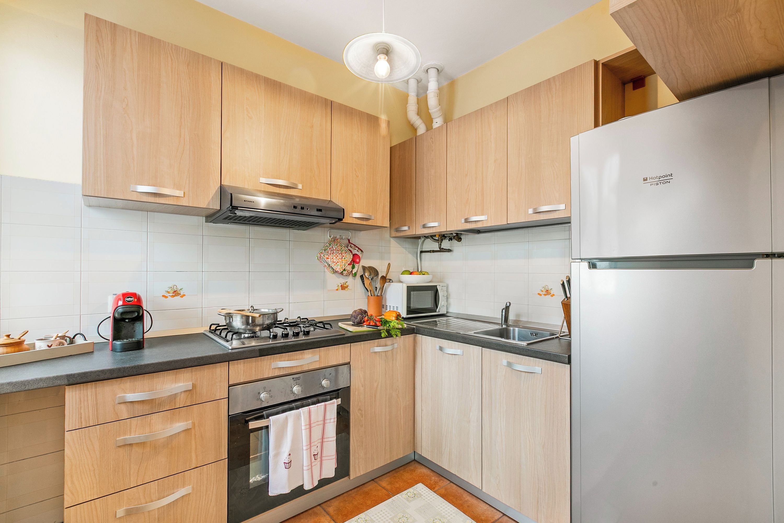 A modern kitchen with wooden cabinets, stainless steel appliances, a gas stove, and a built-in microwave.
