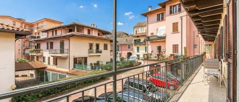 Un quartier résidentiel avec des immeubles à plusieurs étages, un balcon doté d’une rambarde et des voitures garées.