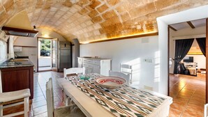 A spacious kitchen with a dining area, a large window, and a view of the outdoors. - A rural idyll with pool – Villa Es Figueral (Campos)
