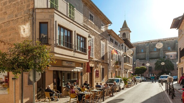 A street with outdoor seating, a café, and a church. - A rural idyll with pool – Villa Es Figueral (Campos)
