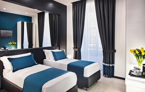 Una habitación de hotel moderna con dos camas, un espejo grande y vistas a la ciudad.