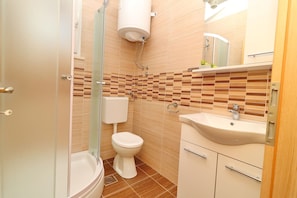 A bathroom with a toilet, sink, and shower. - Holiday Home Adriatic View (Blato)