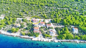 An aerial view of a coastal residential area with houses surrounded by greenery and a clear blue sea. - Holiday Home Adriatic View (Blato)