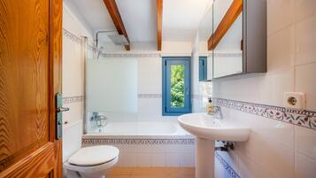Un baño con inodoro, lavamanos y bañera.