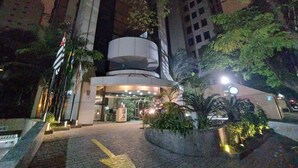 A multi-story building with a central courtyard, surrounded by trees and a paved walkway. - Cyclinn Faria Lima Itaim (São Paulo)