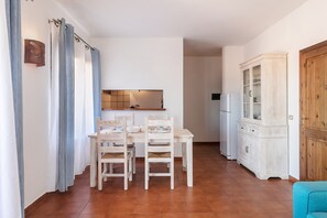 A dining area with a table and chairs, a cabinet, and a wooden door. - Three-Room Apartment in the Center with Sea View (Palau)