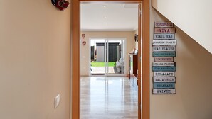 A hallway leading to a glass door with a view of a garden. - Family-Friendly Home Casa Noah Close to Beach with Pool, Terrace, Balcony & Wi-Fi (CONIL de la Frontera)