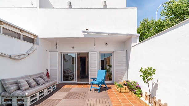 A modern patio with a sofa, a blue chair, and a small garden area. - Family-Friendly Home Casa Noah Close to Beach with Pool, Terrace, Balcony & Wi-Fi (CONIL de la Frontera)
