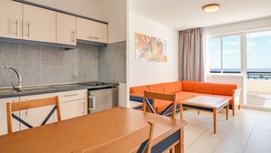 Una cocina moderna con comedor, sofá y vista al mar.