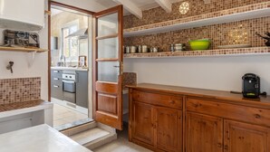 A kitchen with a wooden cabinet, a countertop, and a window. - Fantastic Country Estate with Pool, Wi-Fi, Air Conditioning and Tennis Court (Pollensa)