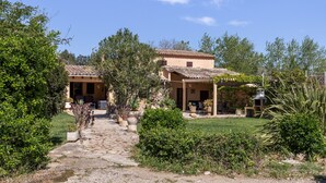 A house with a stone pathway leading to a patio area with outdoor furniture. - Fantastic Country Estate with Pool, Wi-Fi, Air Conditioning and Tennis Court (Pollensa)