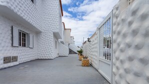 A narrow street with white buildings, a clear sky, and potted plants. - Lovely Apartment Close to the Beach with Terrace, Garden & Wi-Fi (Costa Calmar, Fuerteventura)