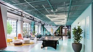 A modern indoor space with a pool table, seating areas, and a staircase leading to an upper level. - The Social Hub Amsterdam West 4 (Amsterdam)