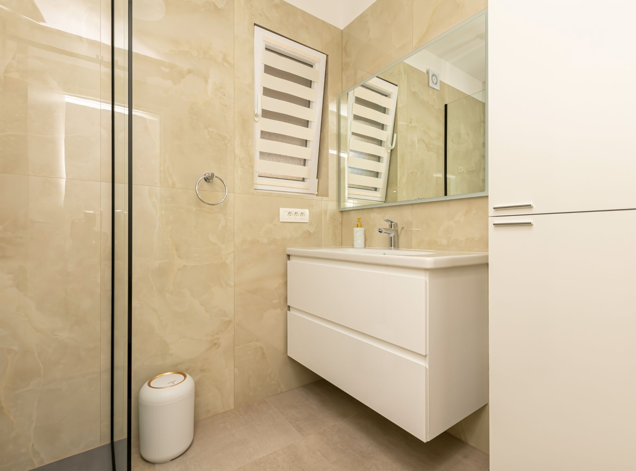 A modern bathroom with a glass shower enclosure, a white vanity with a mirror, and a toilet.
