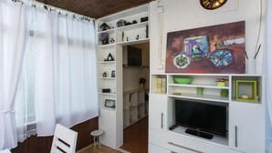 A compact living space with a TV, shelves, and a painting. - Apartment Jeanny (Dubrovnik)