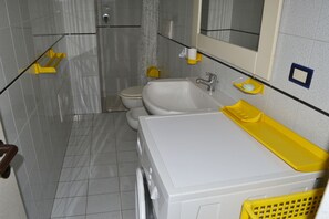 Un baño con inodoro, lavamanos y espejo.