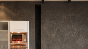 Une cuisine moderne dotée d’appareils électroménagers intégrés, d’une cheminée et d’un coin repas avec des chaises.