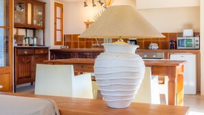 A kitchen with wooden cabinets, a white vase on a table, and a microwave. - Beautiful Finca with Wi-Fi, Pool, Lawn, and Patio; Parking Available (Son Servera)