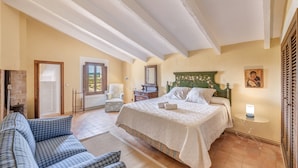 A bedroom with a bed, a sofa, a chair, a small table, and a window. - Holiday Home "Son Galiana" with Wi-Fi, Garden and Terrace (Montuïri)