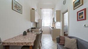 A compact living space with a dining area, kitchenette, and a sofa. - Apartment Old Writer (Dubrovnik)