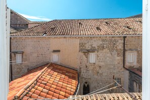 Una calle estrecha con un edificio de techo de tejas y paredes de piedra.