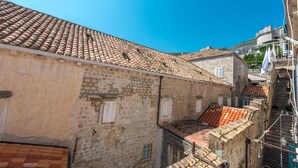 A narrow street with traditional stone buildings, a steep staircase, and a clear blue sky. - Apartment Old Writer (Dubrovnik)