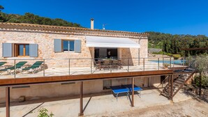 Un bâtiment en pierre doté d’une terrasse, d’un espace extérieur aménagé et d’une piscine.