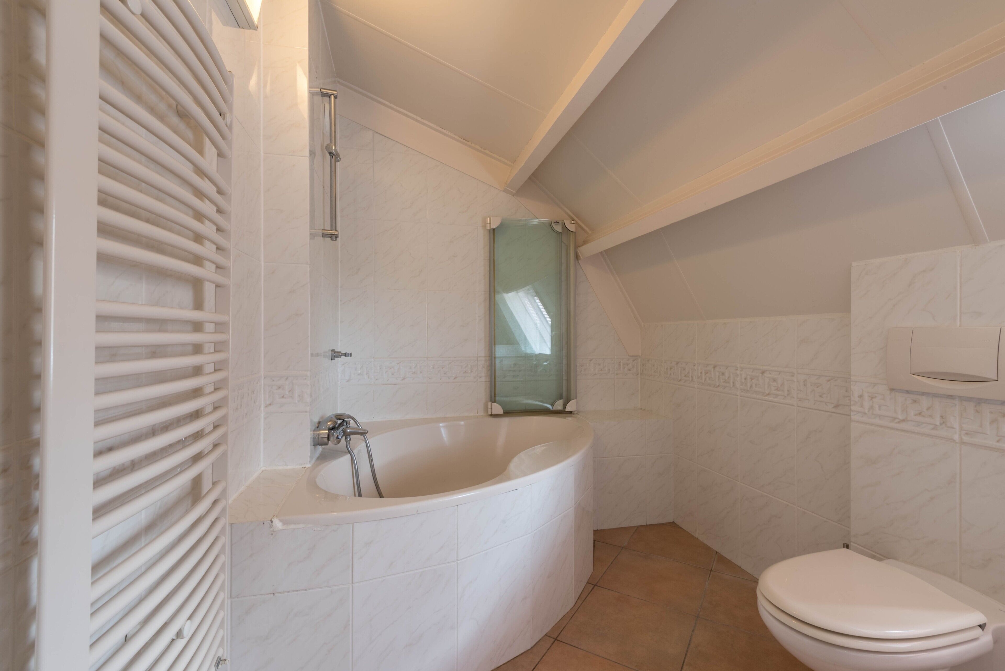 Un baño con bañera, inodoro y cabina de ducha de vidrio.