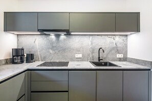 Una cucina moderna con un lavello doppio, una macchina da caffè e una cappa aspirante integrata.