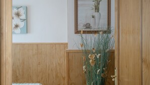A wooden-paneled room with a framed picture and a vase of plants. - Family Friendly Apartment "Rocio" with Terrace, Air Conditioning and Wi-Fi (Conil de la frontera)